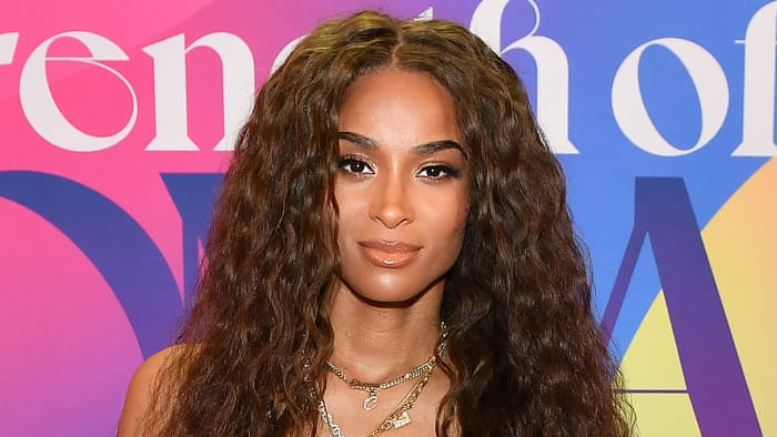 Ciara poses in a series of gold chain necklaces and sports her brown hair in a soft curl.